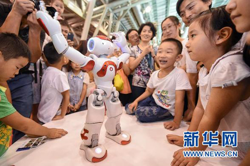7月19日，在安徽国际会展中心，一款智能机器人在给观众表演舞蹈。当日，在安徽合肥举行的第19届RoboCup机器人世界杯赛上，服务机器人、工业机器人、救援机器人等悉数亮相，吸引了众多观众前来参观。新华社记者 张端 摄