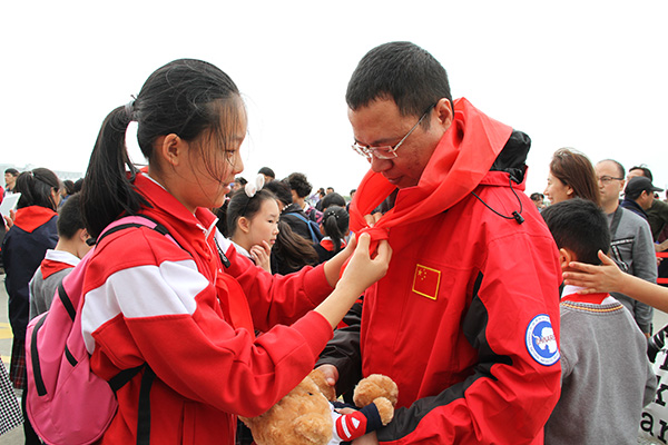 和平里第四小学学生为科考队员佩戴红领巾（晓晓 摄）
