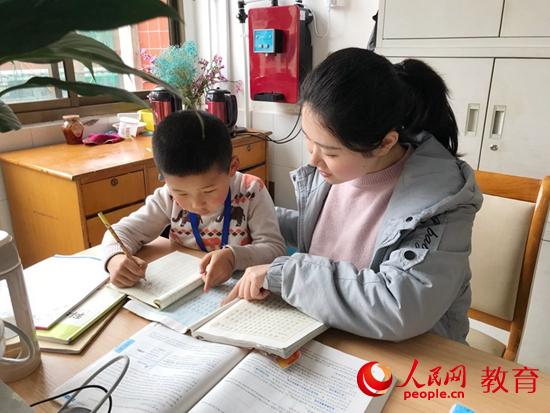 公益老师黄雅琪教学生写作业 卢洁懿/摄